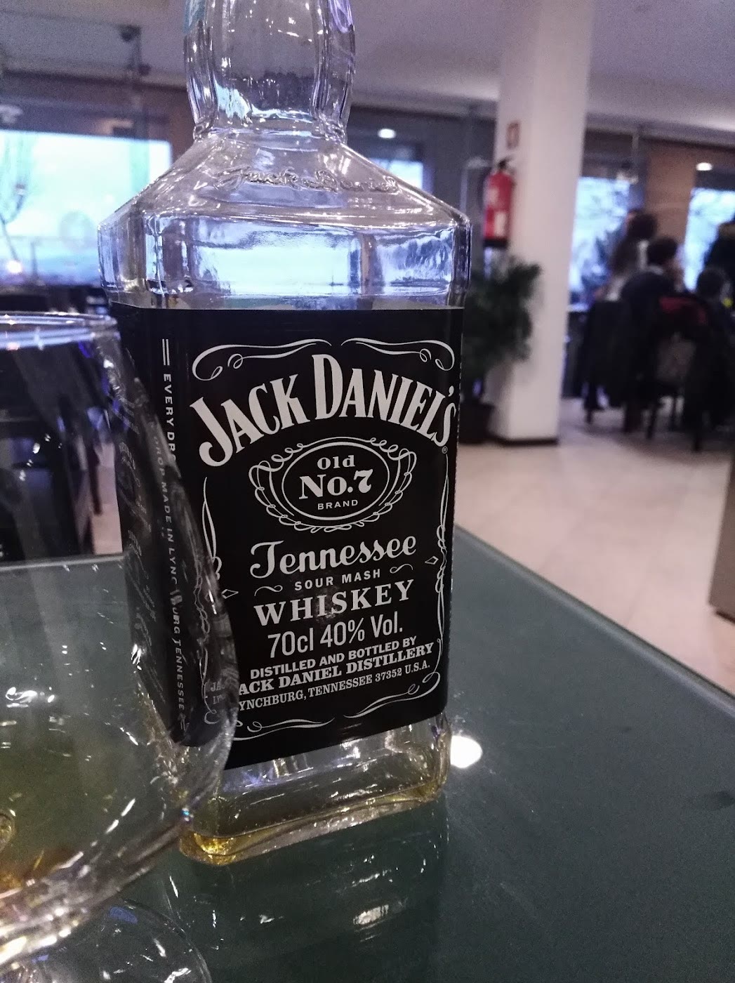 Uma garrafa de whiskey no salão, com o espaço ao fundo